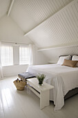 Bedroom under a sloping roof in Scandinavian style