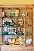 Old-fashioned oak china cabinet with ceramic crockery and decorations