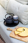 Tea service and lemon tart on upholstered sofa