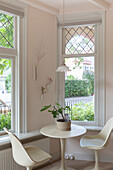 Sitting area with round table and chairs in front of large windows in a modern dining area