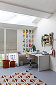 Desk, plant poster and skylight in a modern room