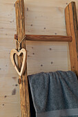 Towel on rustic wooden ladder with heart pendant