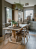 Rustic dining table with wooden chairs and plants in country-style dining room