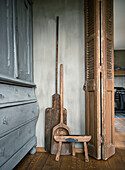 Antique kitchen utensils and wooden stool next to door