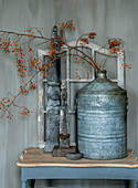 Still life with antique objects and red berry branches on a table