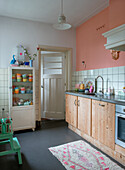Kitchen with wooden cabinets and two-tone walls in pink and white