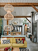 Living room with wooden beams, yellow sofa and rattan lamps