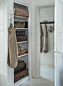 Open built-in wardrobe with vintage suitcases and rustic storage options