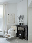 Bright living area with antique wood-burning stove and country-style wicker armchair