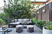 Terrace lounge with grey corner sofa, plants and privacy screen