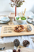 Table setting with pretzels on a DIY wooden board and salad bowl