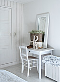 Dressing table with mirror and flower basket in white bedroom