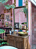 Vintage brass washbasin on wooden consoles in creatively designed bathroom