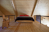 Gallery sleeping area with light-coloured wood panelling and double bed