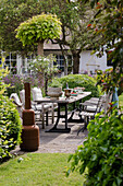 Laid garden table in the green courtyard with wood-burning stove