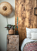 Modern bedside table with hexagonal pattern next to wooden wall in bedroom