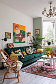 Colourful living room with dark green velvet couch and cheerfully designed decorative cushions