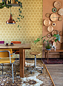 Dining area with wooden table, patterned rug and basket decoration on the wall