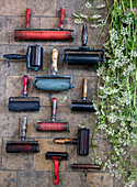 Vintage paint rollers and wild flowers on a stone