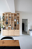 Bright living room with wooden shelf wall and view into hallway