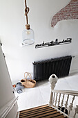 Bright entrance area with black radiator and skyline wall decoration