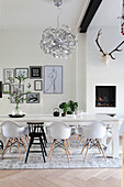 Dining room with white wooden table, fireplace and modern artwork on the wall