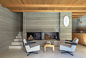 Minimalistisch gestaltetes Wohnzimmer mit Kamin und Holzdecke