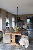 Dining room with large wooden table, upholstered chairs and rustic decorations