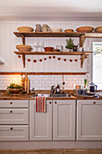 Rustic kitchen with white cupboards, open shelves and wooden elements