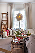 Cosy living area with rustic wine barrel table, candlesticks and star lantern by the window