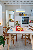 Christmas dining table with wooden chairs in a white kitchen