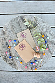 Round wooden table with greeting cards, colourful garland and eucalyptus branch