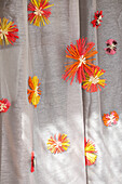 Curtain with colourful raffia stars in bright colours