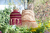 Two hanging raffia lamps in the garden