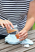 DIY cosmetics: woman fills liquid into pump bottle