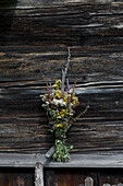 Bouquet of herbs in front of a weathered wooden wall