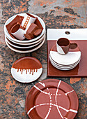 Stacked plates and cups in a hand-painted ceramic look on a rusty background