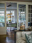 View through sliding glass door into dining room with glass pendant lights and large window