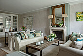 Elegant living room with fireplace, antique mirror and wooden dining table