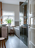 Modern bathroom with light grey tiles and glass shower