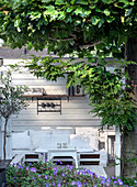 White seating area made of pallets on terrace, surrounded by plants