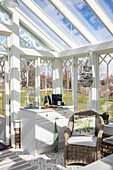 Conservatory with rattan armchairs and small kitchenette