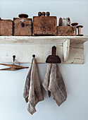 Vintage utensils on a rustic shelf with fabric towels