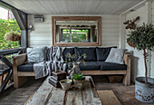 Covered terrace with wooden furniture and plant arrangement