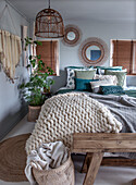 Cozy bedroom with mirror decoration and hanging rattan lamp