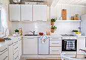 White kitchen with herb pots and patterned towels