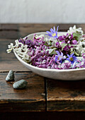 Bowl with colorful spring flowers on a rustic wooden table