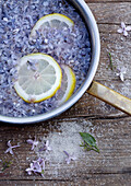 Pot with lilac blossoms, lemon slices and sugar