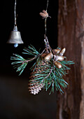 Christmas door decoration made from pine cones, golden acorns and a bell