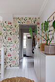 Hallway with floral wallpaper and white-painted wooden floor